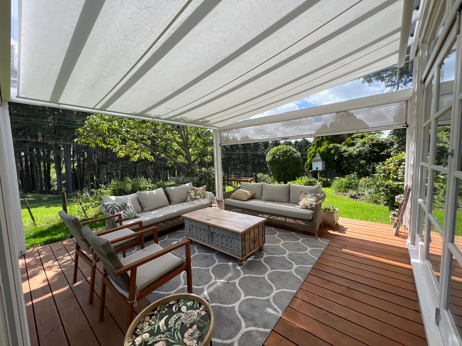 Freestanding white pergola over a paved patio